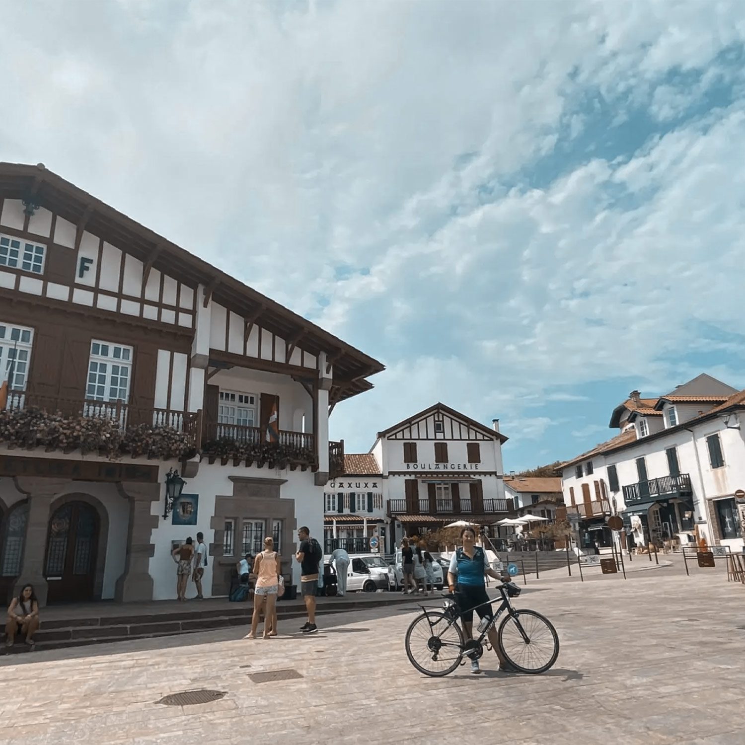 Excursión en bicicleta + Menu Txakolineria, mujer descansando con la bicicleta en un pueblo vasco francés